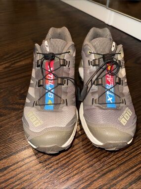 Salomon trail shoes in olive green with blue and red accents